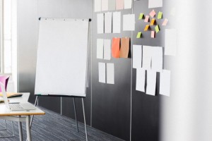 Flip chart by sticky notepapers on wall in office